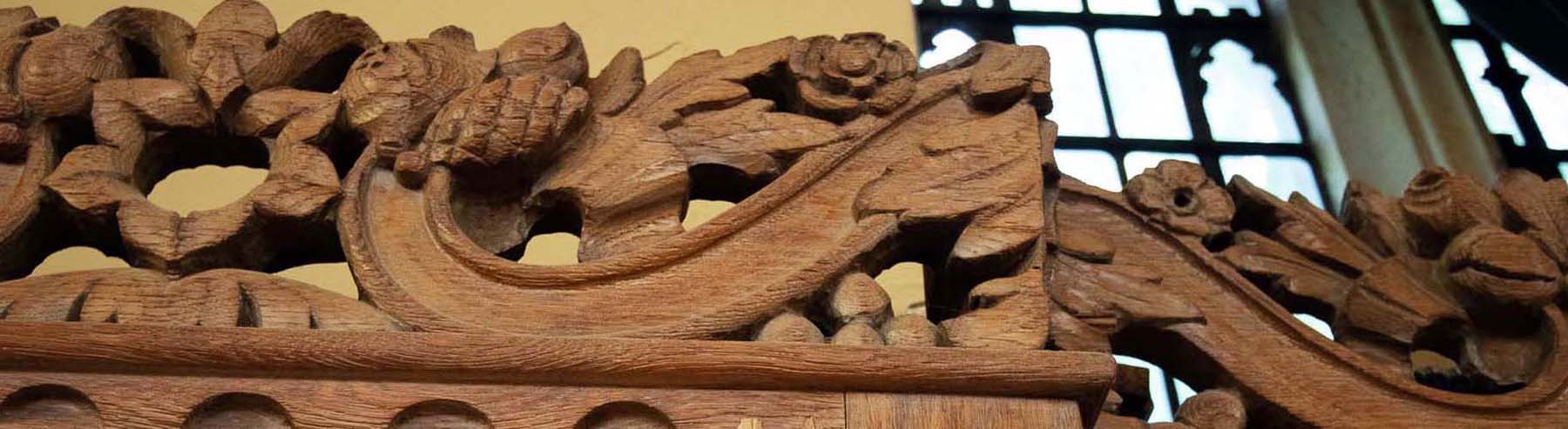 Ornate floral wooden carving on top of the bookshelves